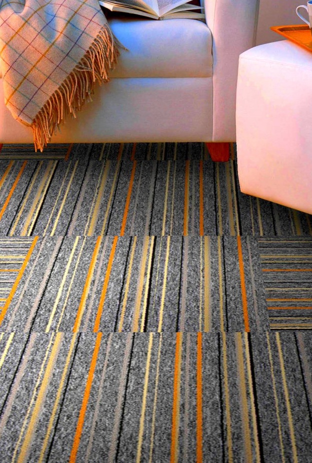 موكيت بألوان الأحمر والبرتقالي الجريء تنسجم مع دهانات الحوائط.