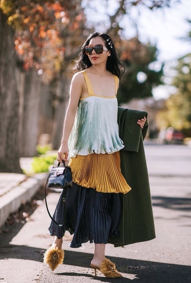 إطلالة خارجة عن المألوف بتنسيق قميص وتنورة مفصلة بموضة الكسرات