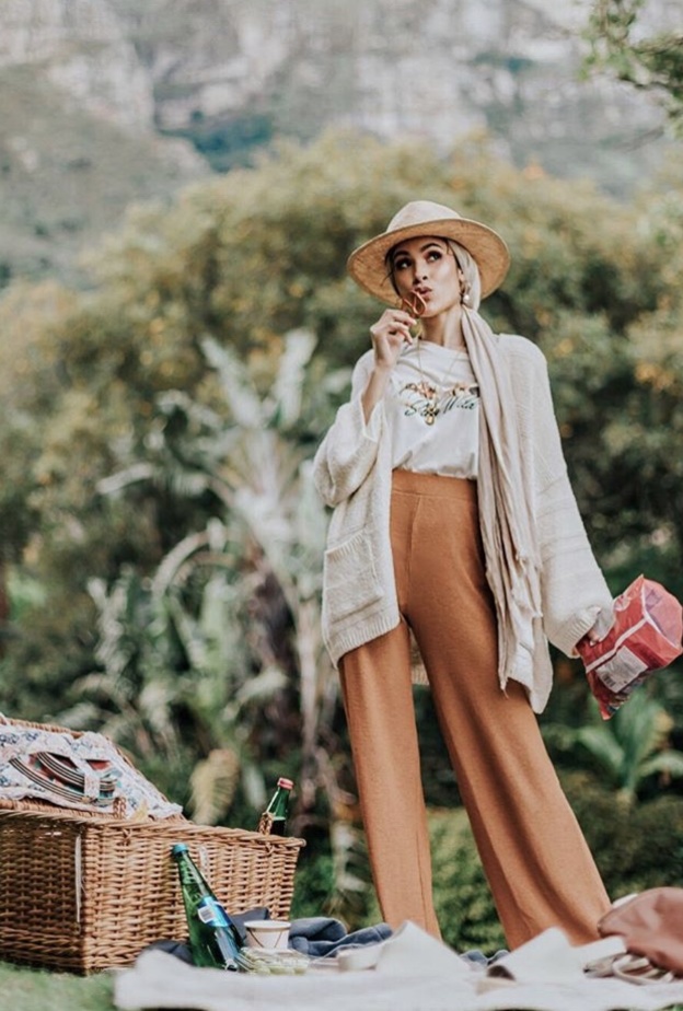 إطلالة جريئة نسقتها نبيلة مع قبعة كبيرة باللون الأسود مع لفة حجاب بنفس اللون وفستان ماكسي طويل مع اكسسوارات جريئة وبارزة