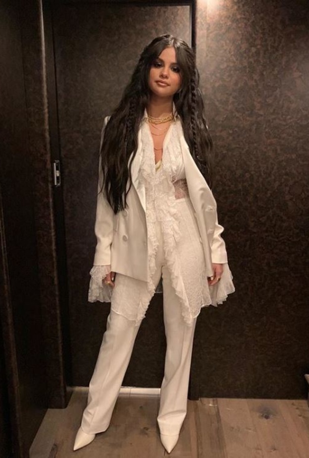 إختارت جيجي سترة من دون أكمام بلون بيج داكن نسّقتها مع سروال flare pants، وحذاء أسود