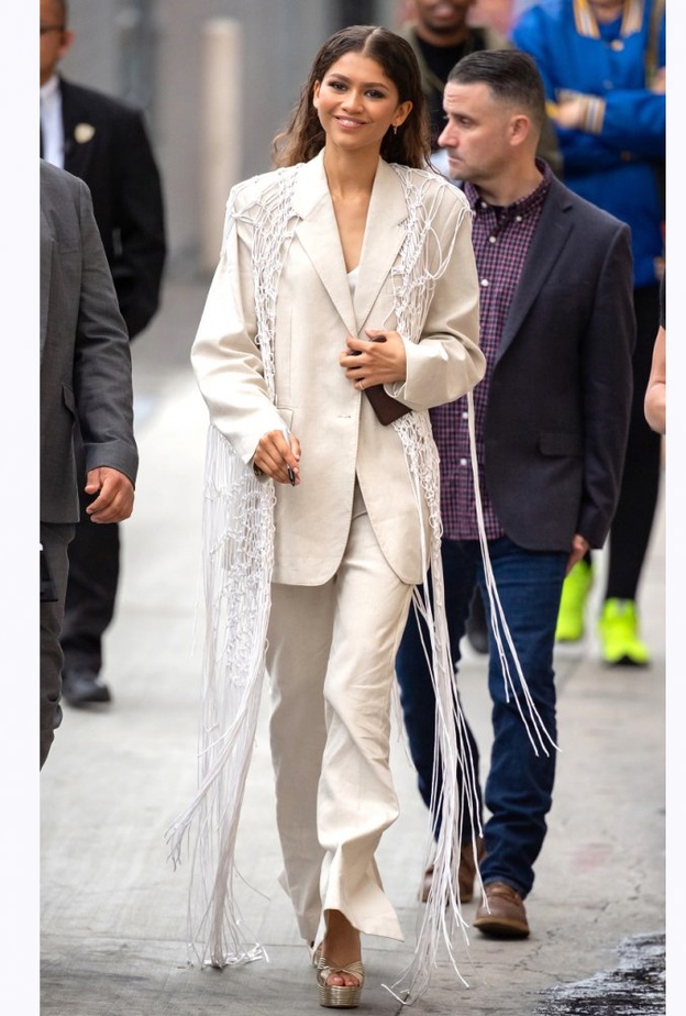  إطلالة عصرية ببدلة بيضاء مع سترة من الشبك والشراريب الطويلة