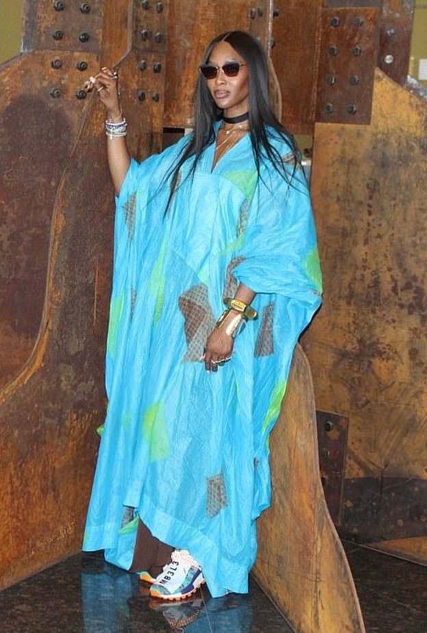 أطلت كامبل بقفطان بلون أزرق وبقصة واسعة، تميّز برقعات باللونين الأخضر والبنيّ