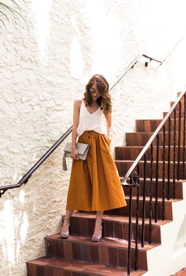 استوحي اطلالاتك الكاجوال بتنانير الميدي الجذابة مع التيشرت والأحذية الرياضية