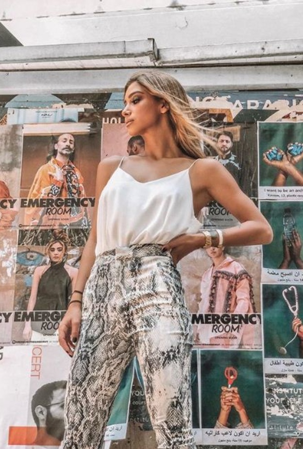 إختارت البلايزر الكلاسيكية باللون الزهري الفاتح وبقصة واسعة ونسقتها مع الدينيم الممزق