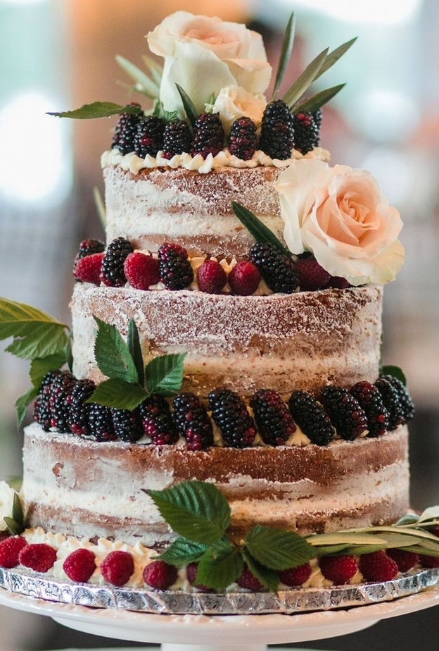 كعكات الزفاف البيضاء متعددة الطبقات والمزينة بزهور ملونة جميلة