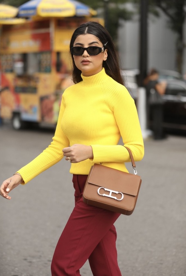 أسيل عمران اثناء حضورها عرض مجموعة كارولينا هيريرا متألقة بفستان من مجموعة الألبسة الجاهزة وحقيبة CH Carolina Herrera Initials Insignia باللون الأبيض 