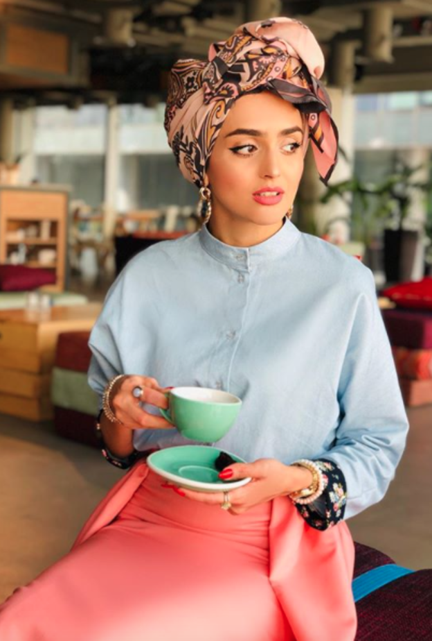 غادة عثمان بأسلوب أنيق بالقميص الأزرق مع التنورة باللون الزهري والتوربان الملون