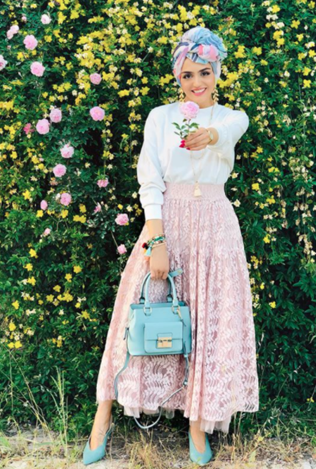 جاذبية غادة عثمان بالتنورة الدانتيل الزهرية مع التوب الأبيض والاكسسوارات باللون الأزرق