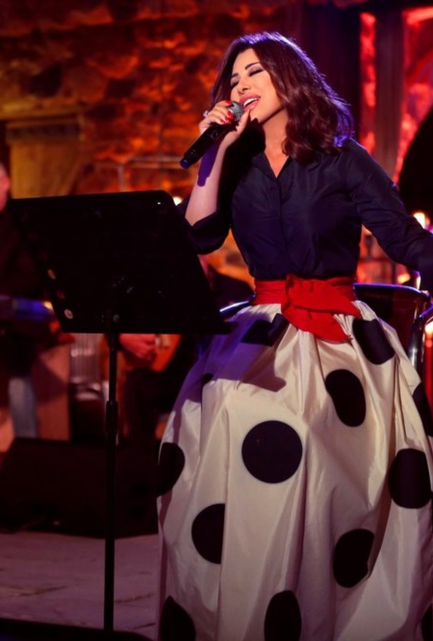 حددت نجوة خصرها بحزام أحمر