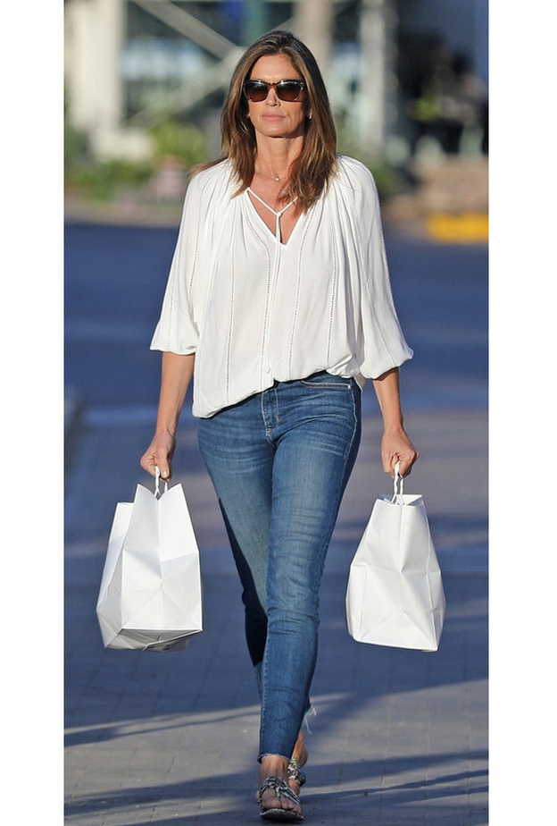  إطلالة CINDY CRAWFORD أثناء التسوق بموضة الجينز الضيق مع التوب البيضاء الواسعة