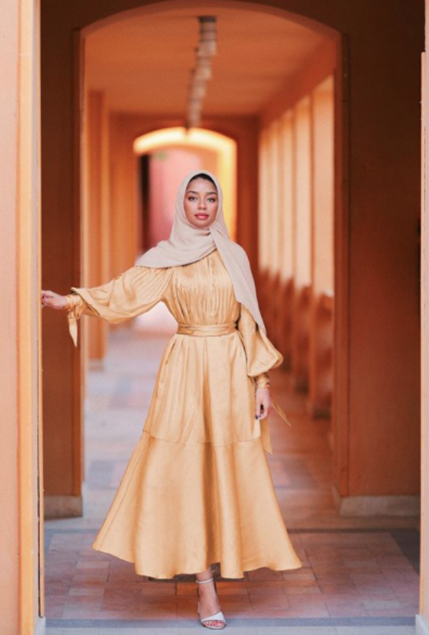  صفيّة غودسون باطلالة بسيطة وناعمة بفستان ميدي باللون الأصفر مع الصندل البيج الفاتح