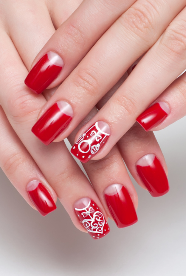 مناكير اللون الاحمر مع نقوش بسيطة من اللون الابيض ليوم المراة الاماراتية