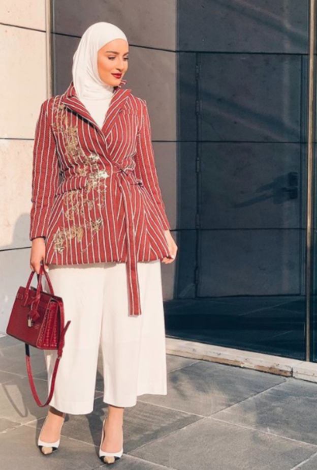 نسقت دلال الدوب البنطلون الأبيض مع بليزر مقلم