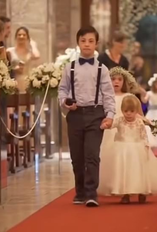 الاطفال متجهين نحو العروسين يتقدمهم أكبرهم و هو يحمل خاتم الزواج