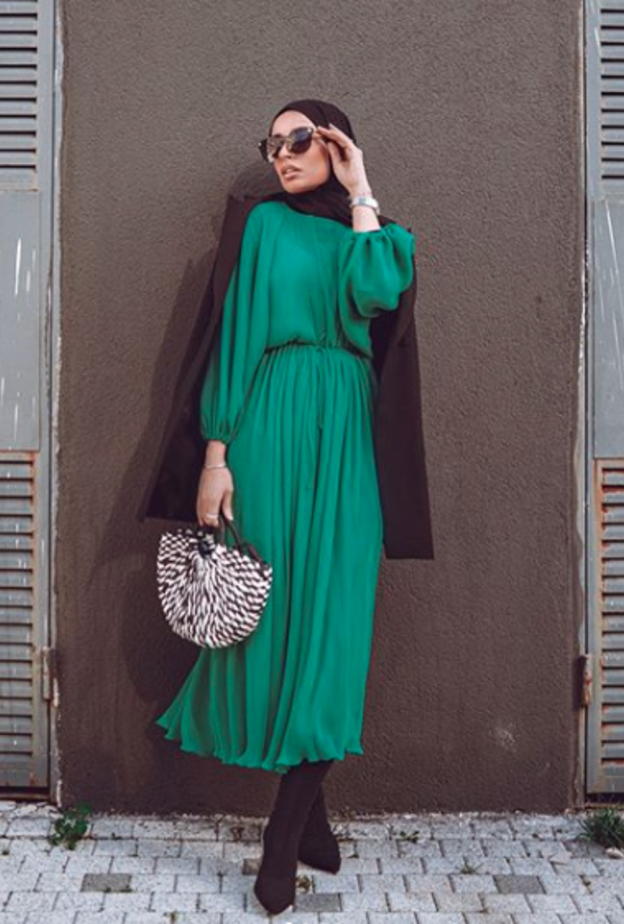 الأخضر الجذاب باطلالة شبابية بسيطة بالفستان الميدي مع الحذاء الشتوي العالي باللون الأسود والحقيبة باللونين الأبيض والأسود