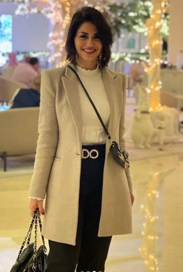 إختاري البنطلون الأسود مع التوب الأبيض بالياقة العالية وأكملي اللوك بمعطف أنيق