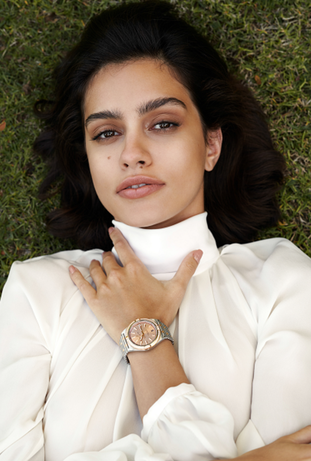 ساعة كرونومات أوتوماتيك 36 Chronomat Automatic 36 من الفولاذ المقاوم للصدأ والذهب الأحمر عيار 18 قيراطا، ومزدانة بمجموعة من الأحجار الكريمة وميناء نحاسي. من دار "بريتلينغ" Breitling. قميص من "جيني" Genny.