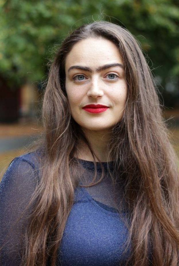 فتاة دانماركية تتحدى معايير الجمال بحواجب متصلين وشارب