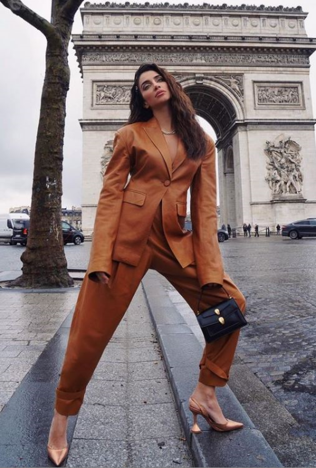 جيسيكا قهواتي إختارت البدلة البنية مع البنطلون بقصة واسعة نسّقت معها حقيبة Bulgari  وحذاء بلون ميتاليكي