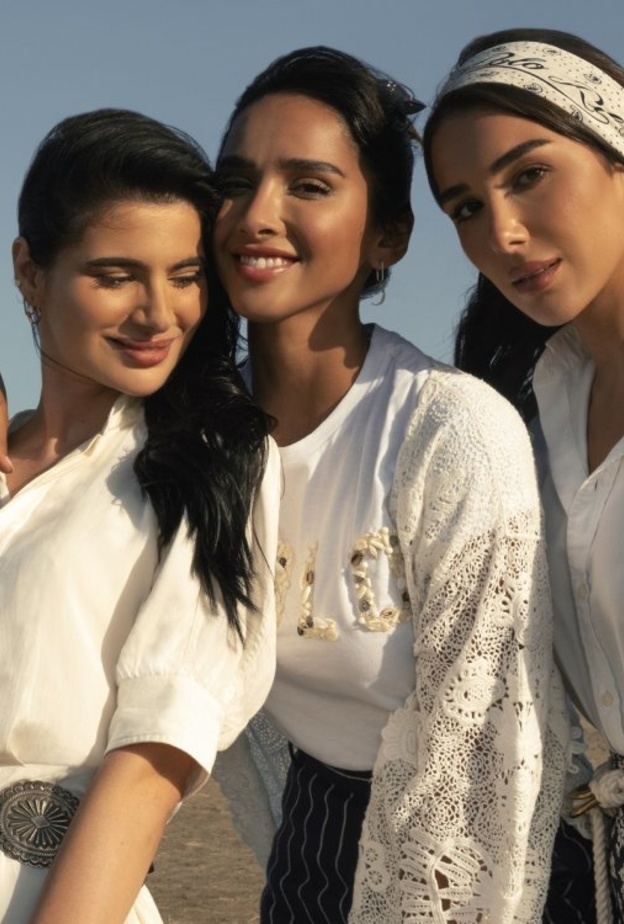 اختارت شينا فستان ميدي تويل من الحرير الأبيض مع حزام مزخرف وحقيبة من القطن سميكة