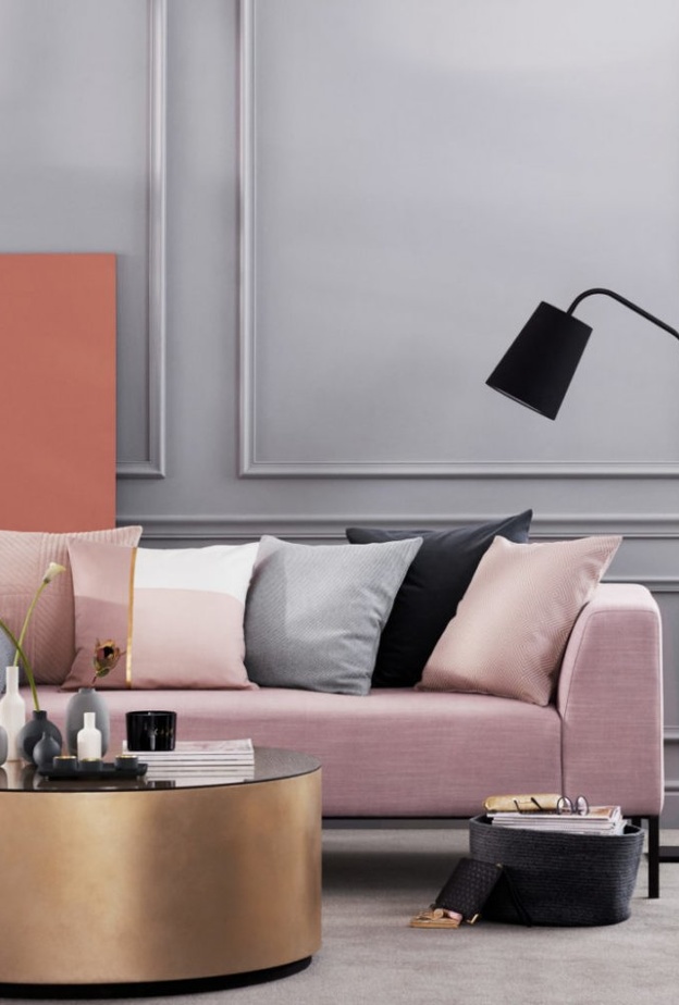  خلفية باللون الرمادي تبرز جمال الكنب بلونه الزهري الفاتح