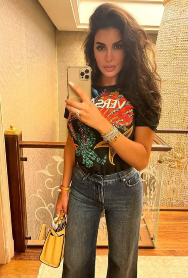 نسّقت تيشيرت من ماركة Versace مع البنطلون الدنيم بقصة الأرجل الواسعة