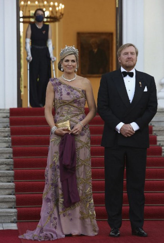 أكملت اللوك بالوشاح باللون البنفسجي الداكن والحقيبة الذهبية