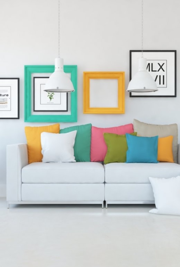 الوسائد الملونة تزين الكنب بلونه الأبيض البسيط