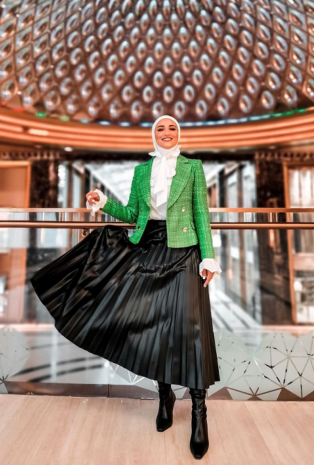 نسقت دلال الدوب البليزر مع التنورة البليسيه باللون الأسود والقميص الأبيض