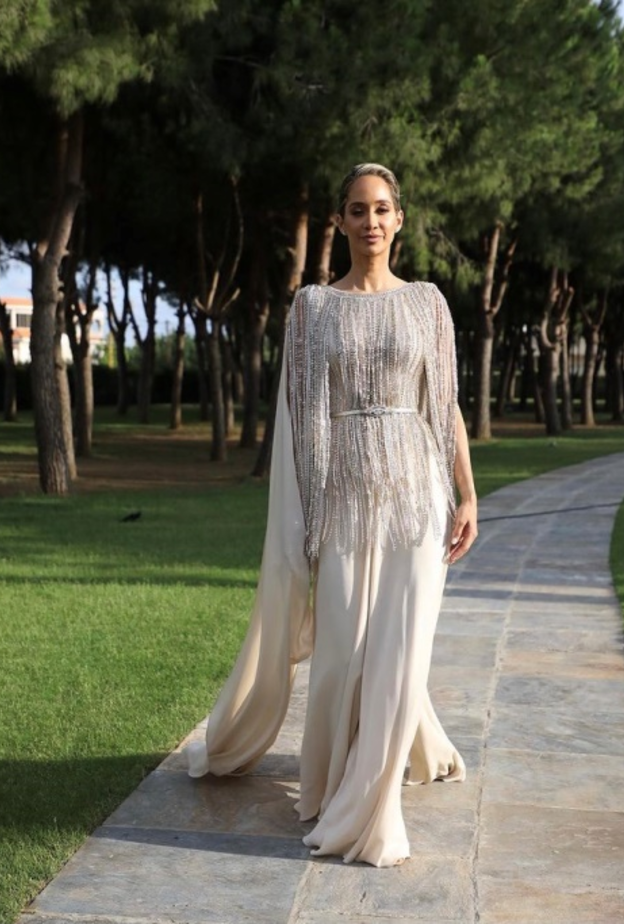 جامبسوت باللون العاجي مرفق بكاب طويل ومزيّن بالشراشيب المرصّعة باللؤلؤ