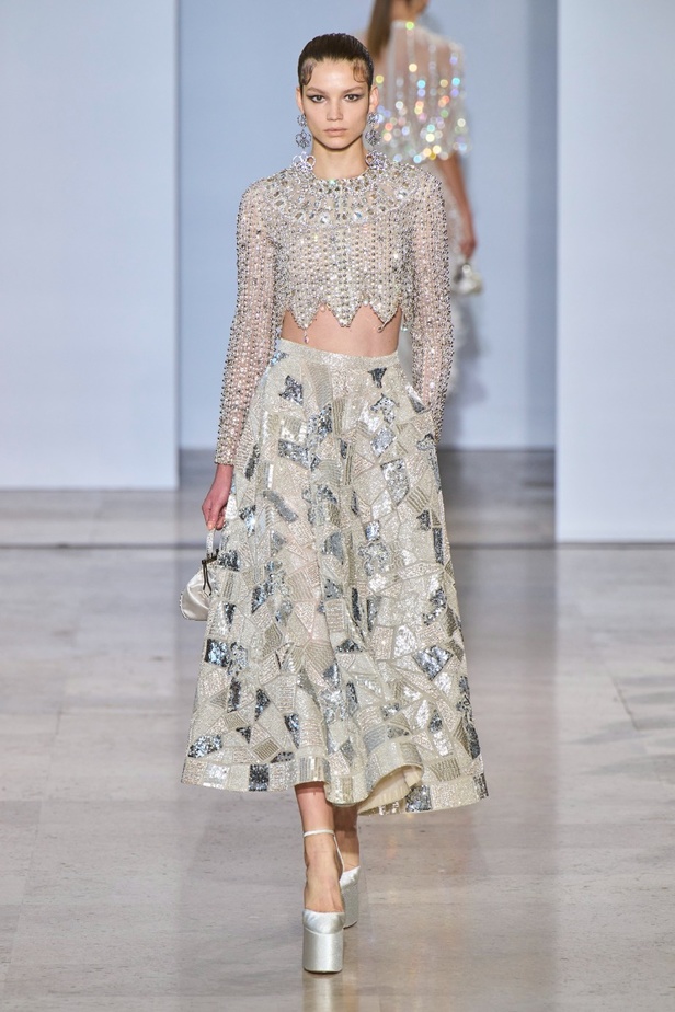 مجموعة دار جورج حبيقة Eternal Gifts  افتتحت العرض مؤثرة الموضة الألمانية ليوني هان بفستان قصير باللون الفضي تميّز بسلاسل معدنية ثلاثية الأبعاد