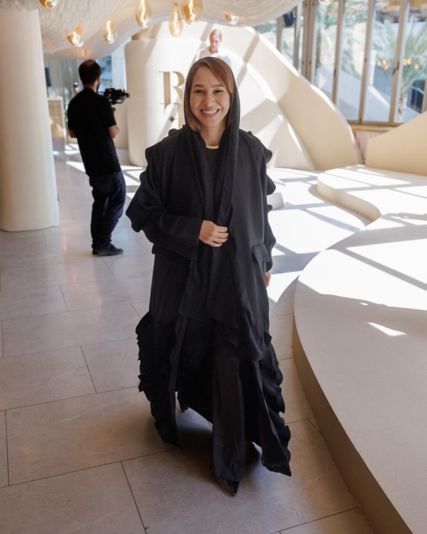 من مجموعة “سرّ الحديقة”، فستان أسود بأكمام مزينة بسوار ذهبي أنيق