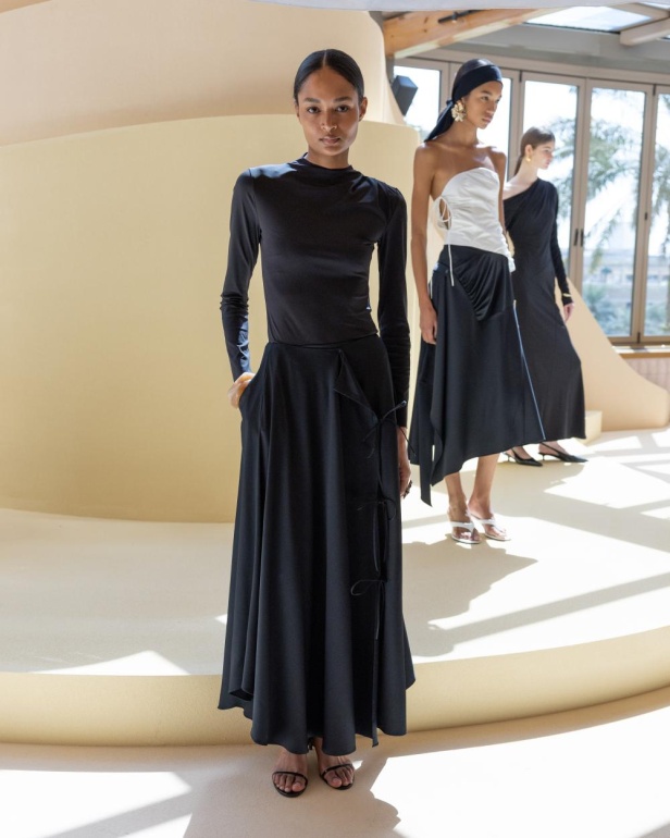 من مجموعة “سرّ الحديقة”، فستان أسود بأكمام مزينة بسوار ذهبي أنيق