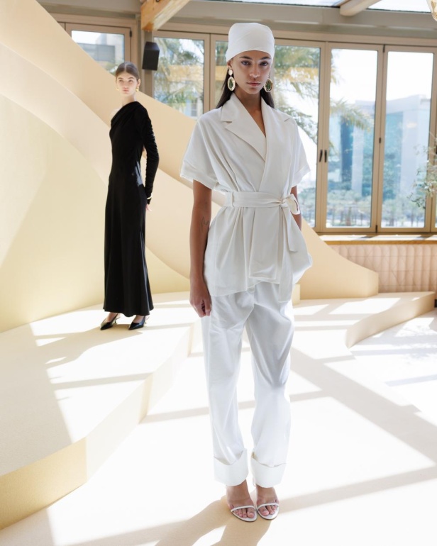 من مجموعة “سرّ الحديقة”، فستان أسود بأكمام مزينة بسوار ذهبي أنيق