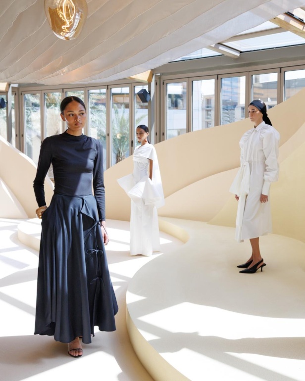 من مجموعة “سرّ الحديقة”، فستان أسود بأكمام مزينة بسوار ذهبي أنيق