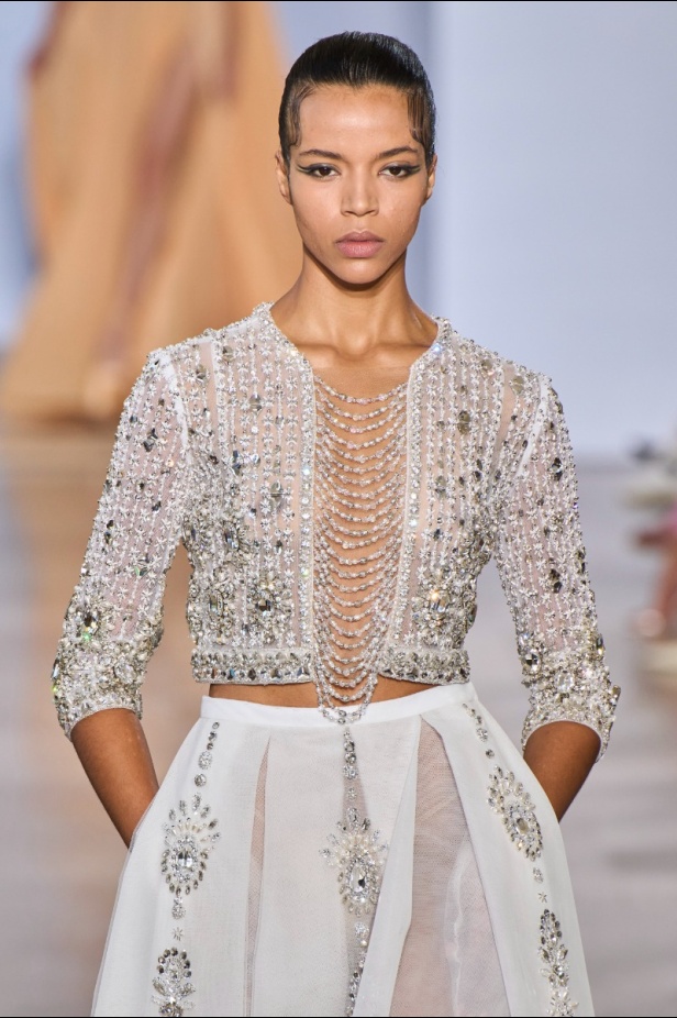 مجموعة دار جورج حبيقة Eternal Gifts  افتتحت العرض مؤثرة الموضة الألمانية ليوني هان بفستان قصير باللون الفضي تميّز بسلاسل معدنية ثلاثية الأبعاد