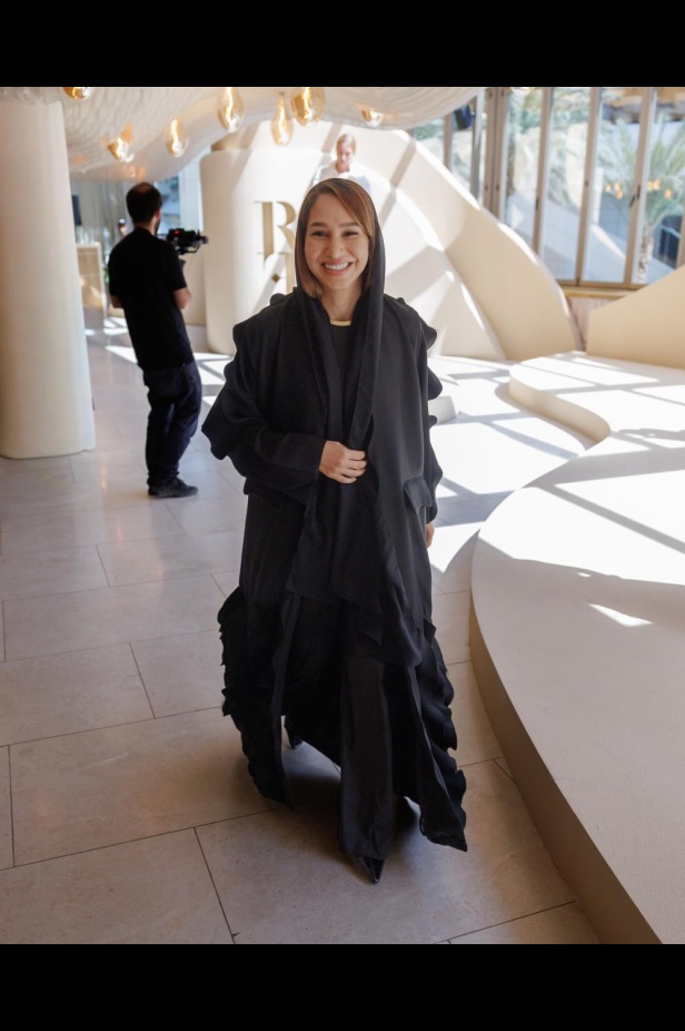 من مجموعة “سرّ الحديقة”، فستان أسود بأكمام مزينة بسوار ذهبي أنيق