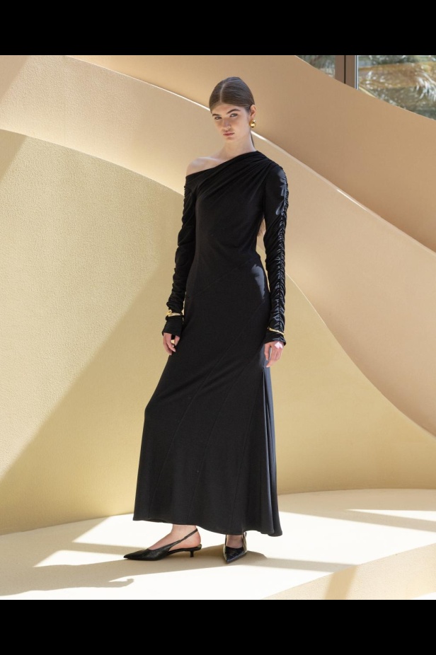 من مجموعة “سرّ الحديقة”، فستان أسود بأكمام مزينة بسوار ذهبي أنيق