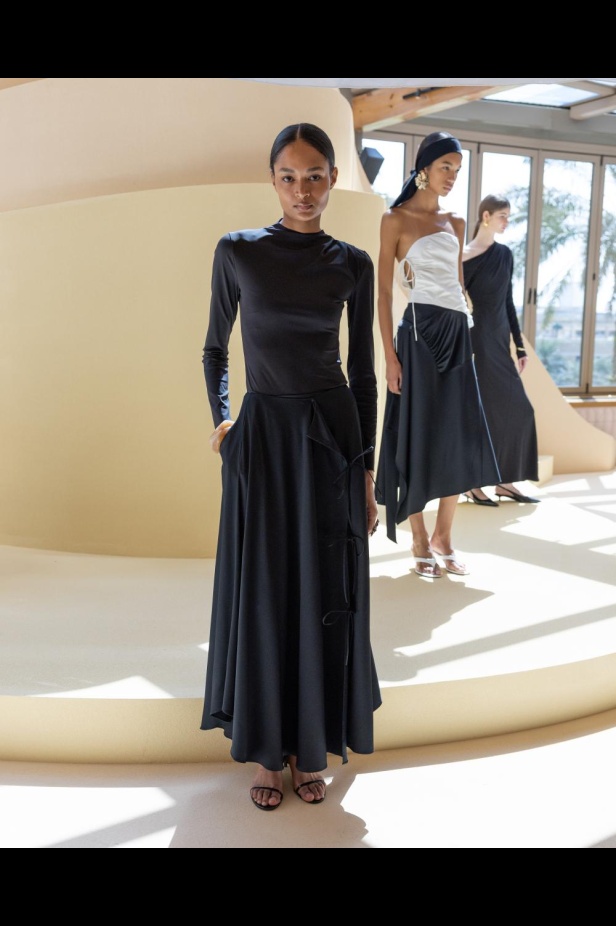 من مجموعة “سرّ الحديقة”، فستان أسود بأكمام مزينة بسوار ذهبي أنيق