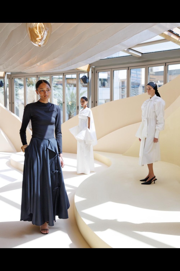 من مجموعة “سرّ الحديقة”، فستان أسود بأكمام مزينة بسوار ذهبي أنيق