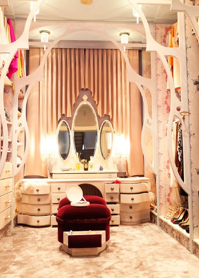 تصميم مميز لغرفة الملابس بأقواس خشبية و المقعد من المخمل الأحمر الذي يحتوي على جوارير  