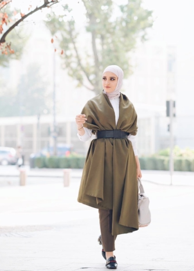 معطف زيتي أنيق نسّقته دلال الدوب برقي مع حزام جلدي أسود عريض