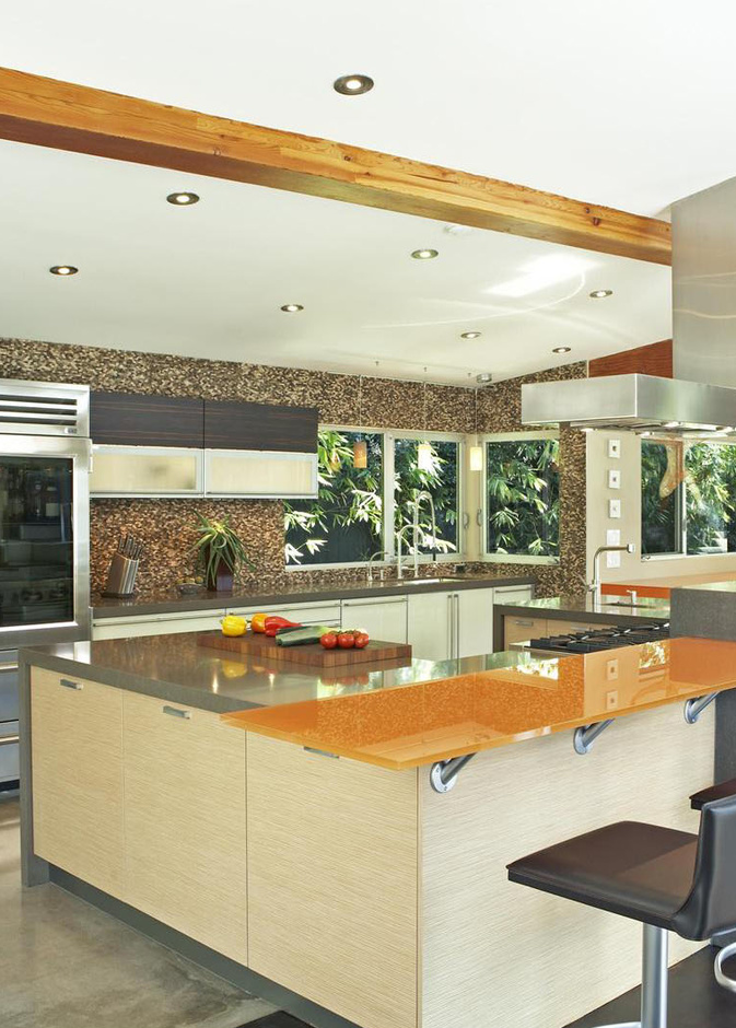 مطبخ عصري استعمل في صنعه الخشب من لونين و الحديد و رف مميز من الزجاج باللون البرتقالي