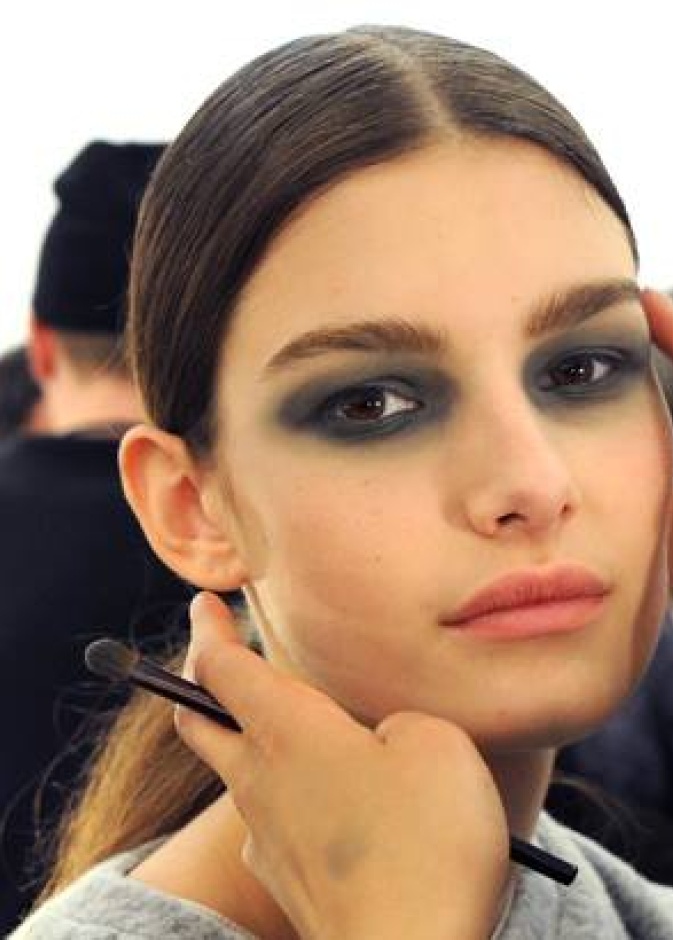 عارضة أزياء تستسلم لأنامل خبير التجميل في عرض أزياء Derek Lam