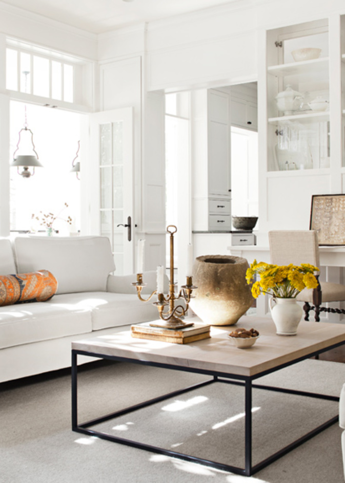 غرفة معيشة باللون الأبيض وطاولة بالكريمي