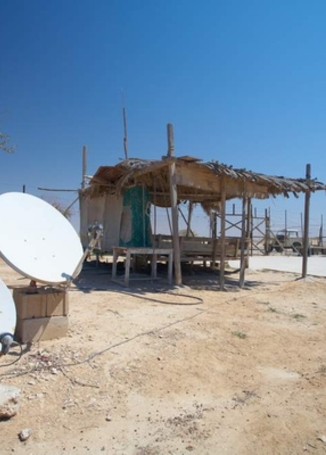 Rural communication through satellite dishes outside a dilapidated old dwelling