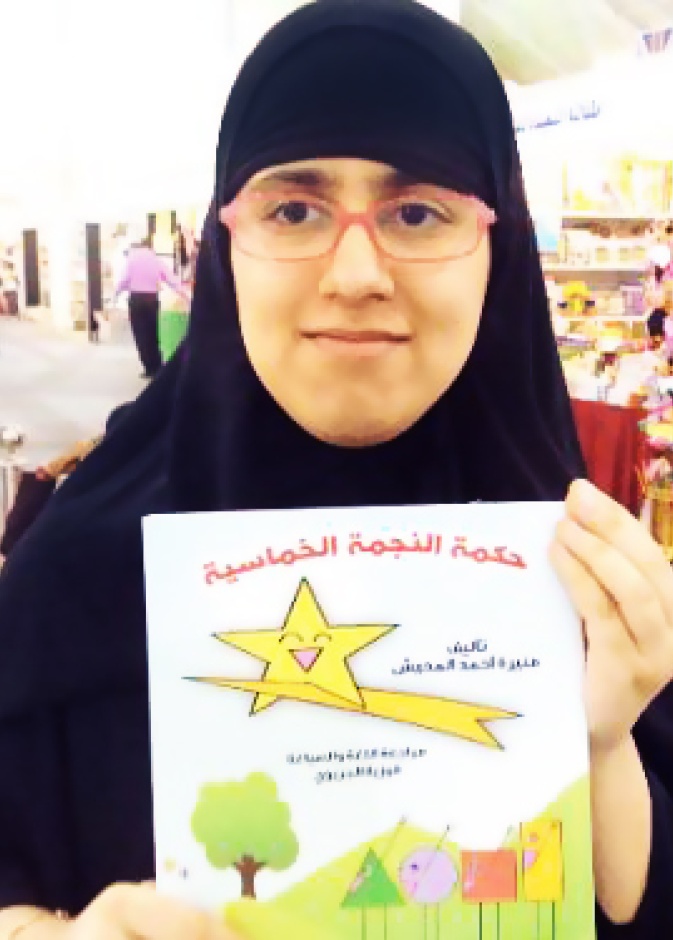 منيرة تمسك بكتابها حكمة النجمة الخماسية