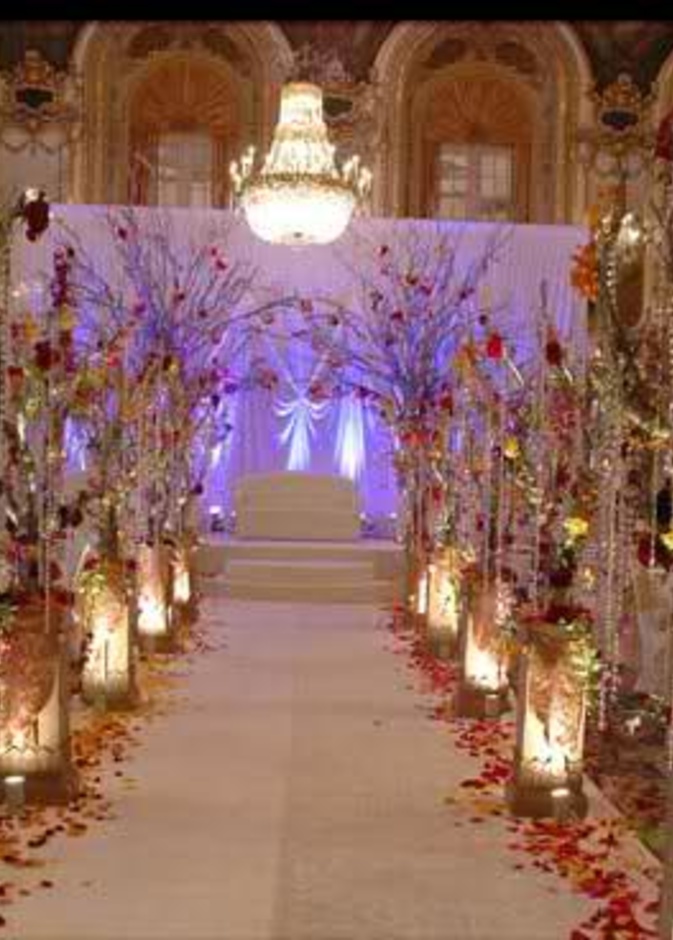 ممر مزيّن بالورد وأعمدة الكريستال مؤدي للكوشة