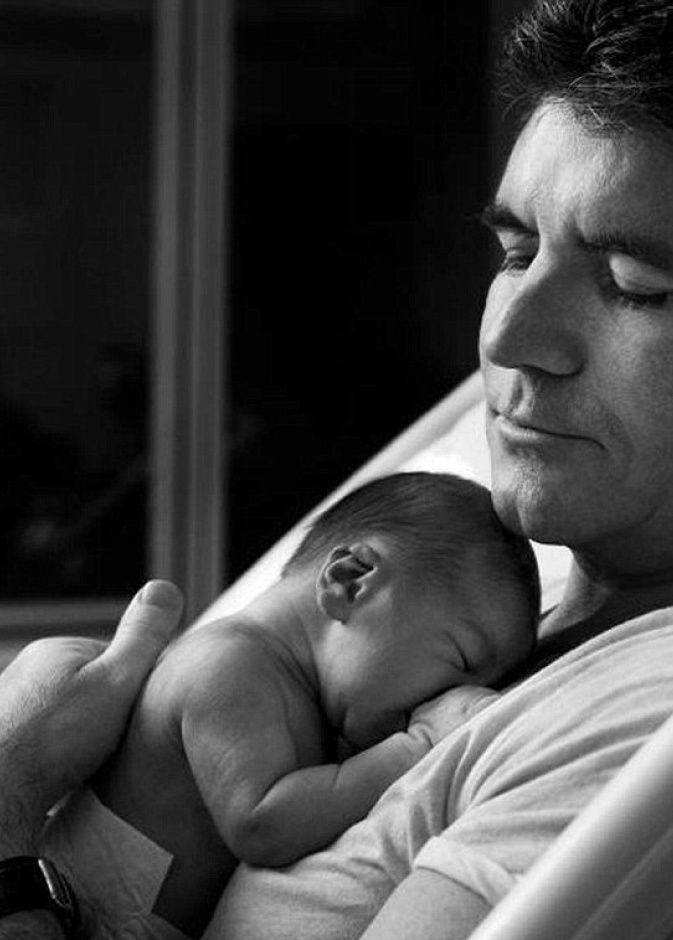  صورة تختصر كل حنان الأبو ة لسايمون كويل وهو يحتضن مولوده الجديد