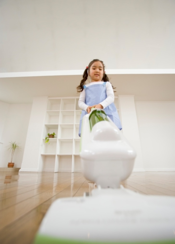 طفلة تستعمل المكنسة الكهربائية